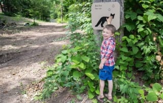 Boy touching red fox trail sign