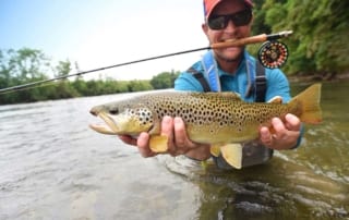 Fly fisherman holding a trout