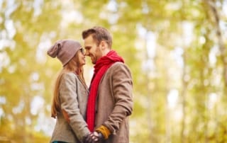 Couple standing in an autumn forest close together