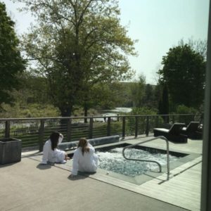 Two people relaxing by the pool of a Catskills resort on their self-planned yoga retreat.