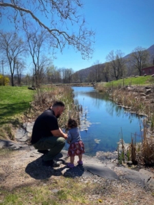 A father and daughter wandering along a creek, one of the popular activities in the Catskills.