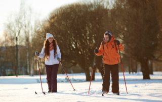 A couple cross-country skiing on a romantic Upstate New York winter vacation.