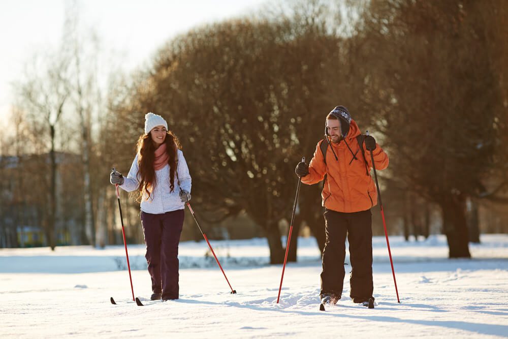 A couple cross-country skiing on a romantic Upstate New York winter vacation.