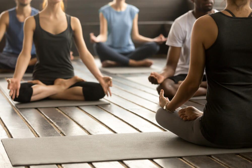 People doing yoga during a digital detox retreat.