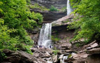 A group of people in front of a waterfall found at the end of one the hiking trails in the Catskills.