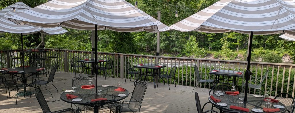Outside deck area at Catamount Restaurant. Tables with umbrellas overlooking the Esopus creek
